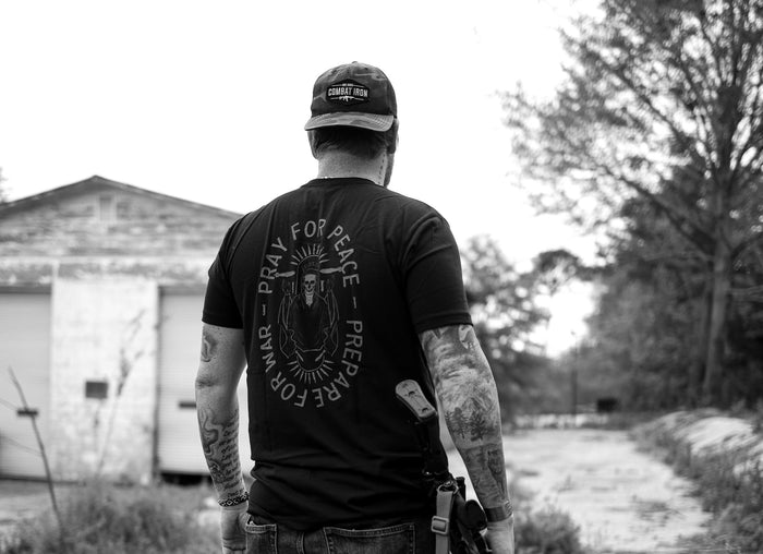 Combat Iron Apparel's veteran-owned company logo, with a proud veteran saluting the American flag in the background. Showing our respect and appreciation for those who served our country.