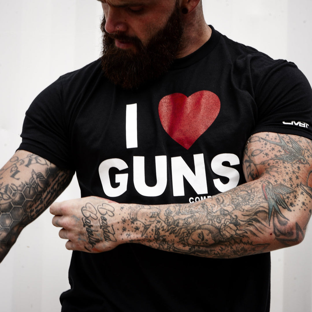 Tattooed Tactical Athlete wearing an I LOVE GUNS Combat Iron Apparel showcasing the sleeve fit and design.