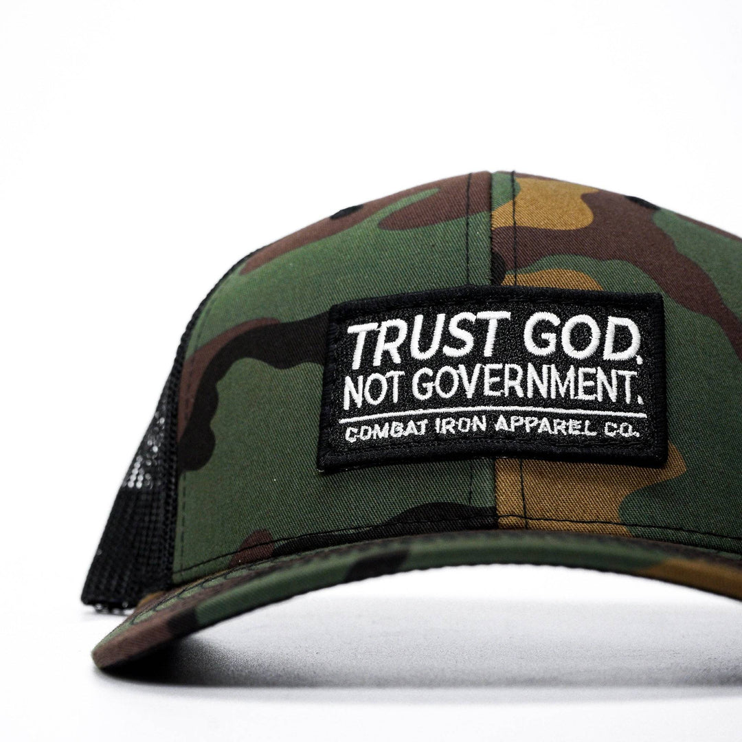 A mid-profile mesh snapback with the words “Trust God. Not government.” in white on the front #color_bdu-camo-black