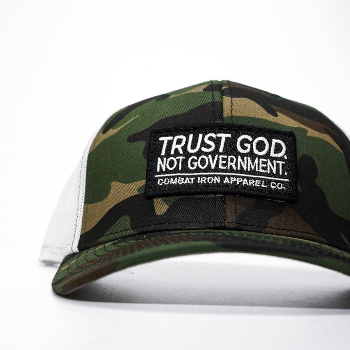 A mid-profile mesh snapback with the words “Trust God. Not government.” in white on the front #color_camo-white