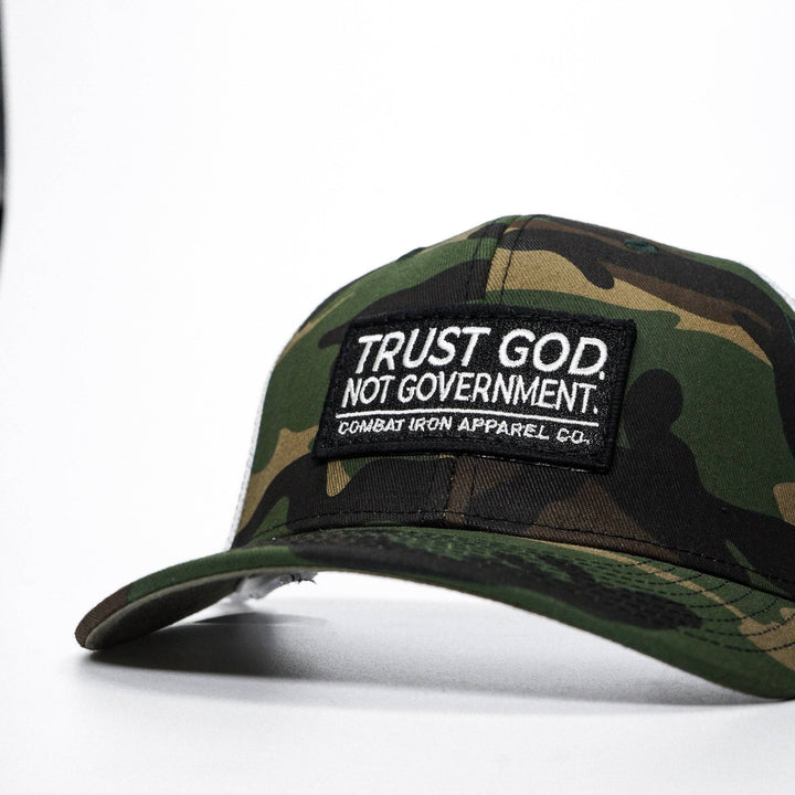 A mid-profile mesh snapback with the words “Trust God. Not government.” in white on the front #color_bdu-camo-white