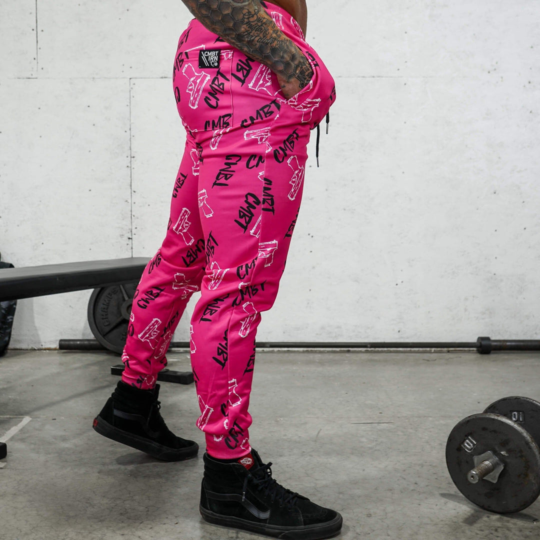 Relaxed fit athletic midweight CMBT branded joggers for men in pink with black and white details #color_pink-cmbt-pistols