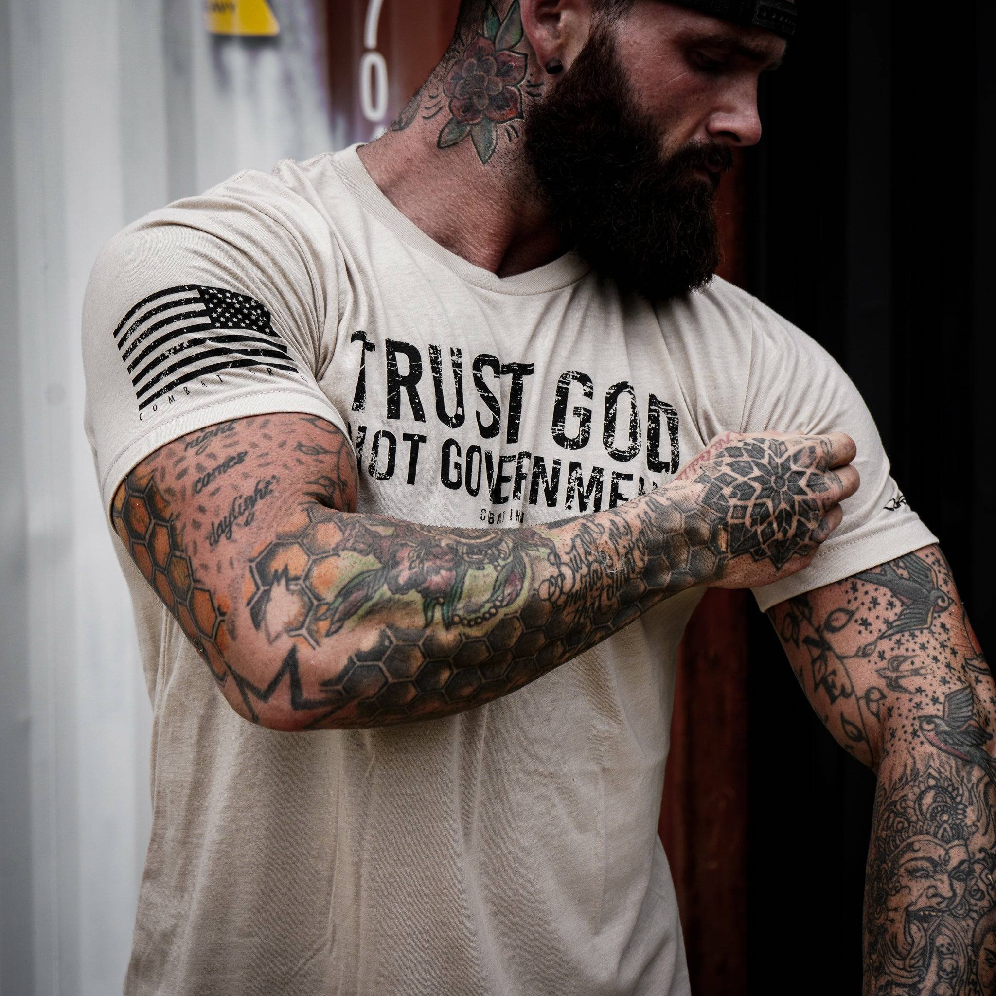 Men’s black t-shirt with the message “Trust God. Not government.” with letters and a American flag on the sleeve #color_tan