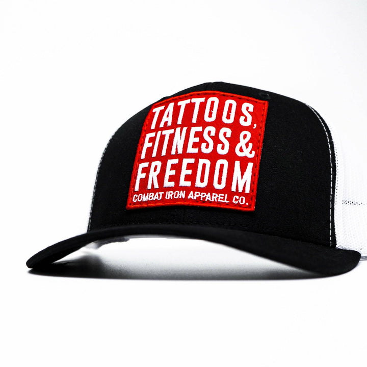 A black mid-profile mesh snapback with a red patch saying “Tattoos, fitness & freedom” in white letters #color_black-white