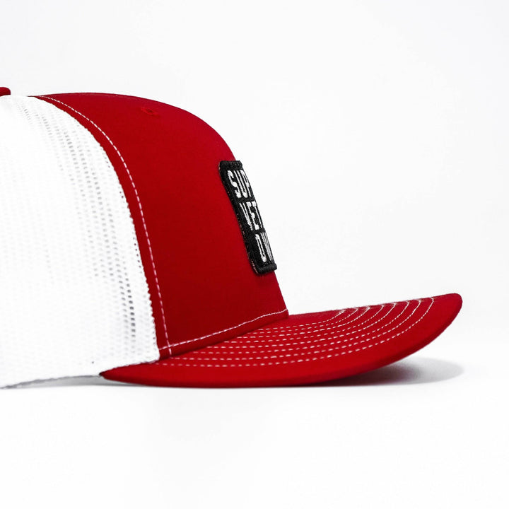 A mid-profile mesh snapback with a patch that says “Support veteran owned” in white letters #color_red-white