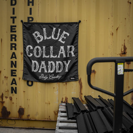 Flag with 'Blue Collar Daddy' text on a yellow container background