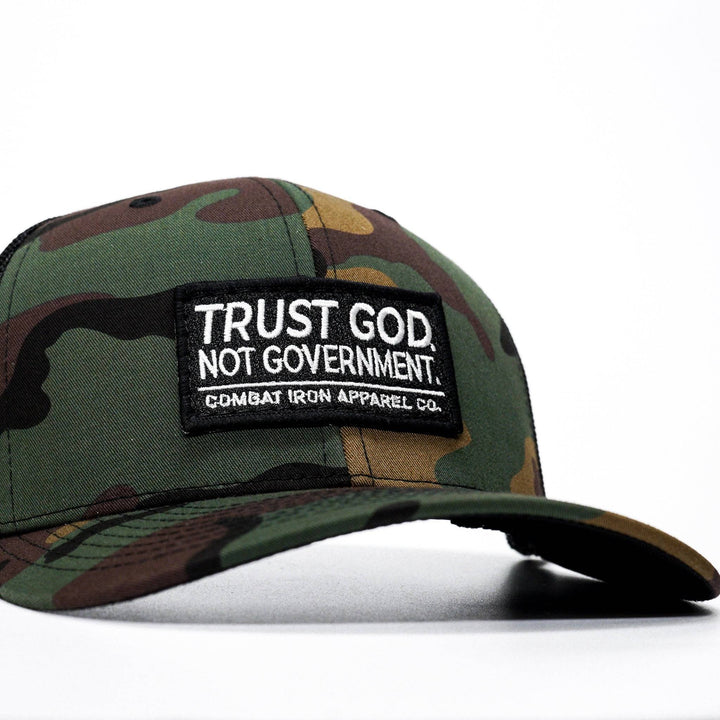 A mid-profile mesh snapback with the words “Trust God. Not government.” in white on the front #color_bdu-camo-black