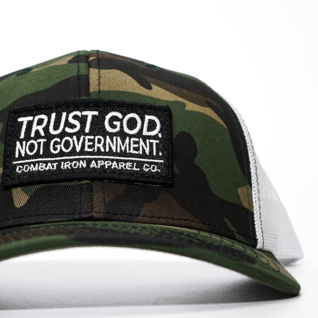 A mid-profile mesh snapback with the words “Trust God. Not government.” in white on the front #color_camo-white