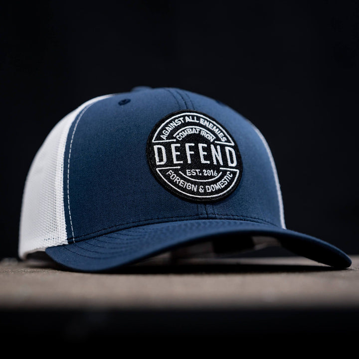 A retro rope snapback with the words “Defend against all enemies, foreign & domestic” on the front #color_navy-white