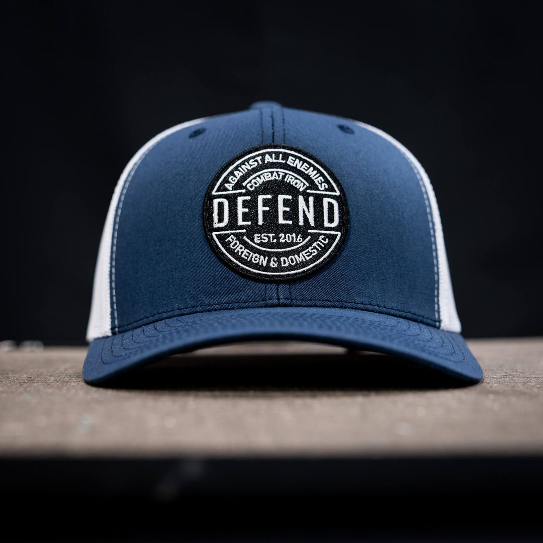 A retro rope snapback with the words “Defend against all enemies, foreign & domestic” on the front #color_navy-white