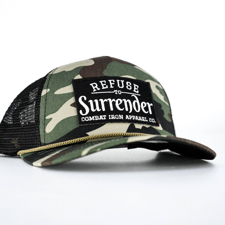 A camo retro rope snapback with a black patch and white letters saying “Refuse to surrender” #color_bdu-camo-black