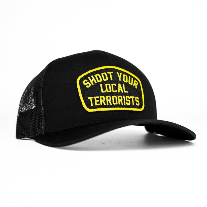 Mid-profile mesh snapback hat in black with a patch that says “Shoot your local terrorists” in yellow #color_black-black