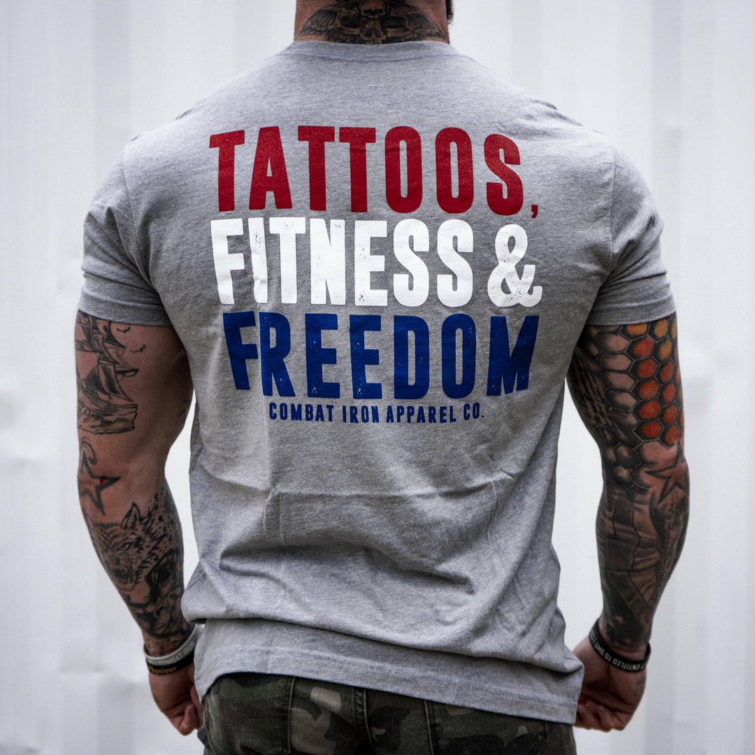 Men’s t-shirt with the words “Tattoos, fitness & freedom” in red, white, and blue on the front  #color_gray
