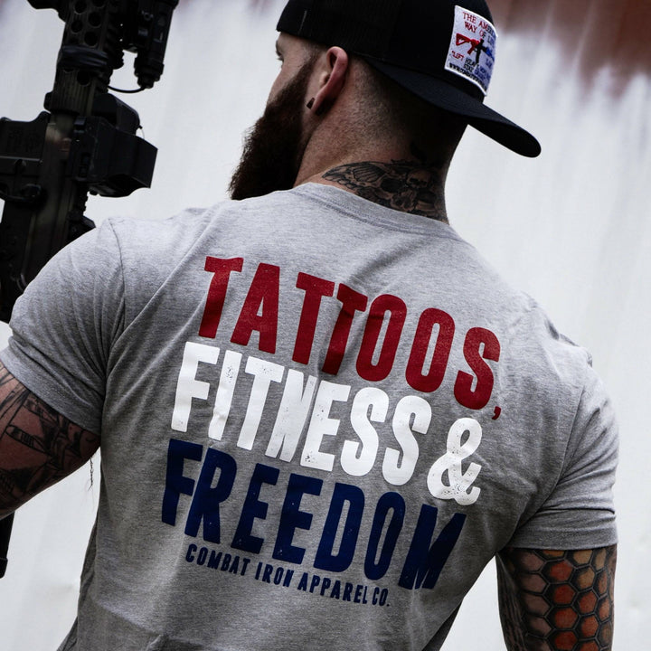 Men’s t-shirt with the words “Tattoos, fitness & freedom” in red, white, and blue on the front  #color_gray