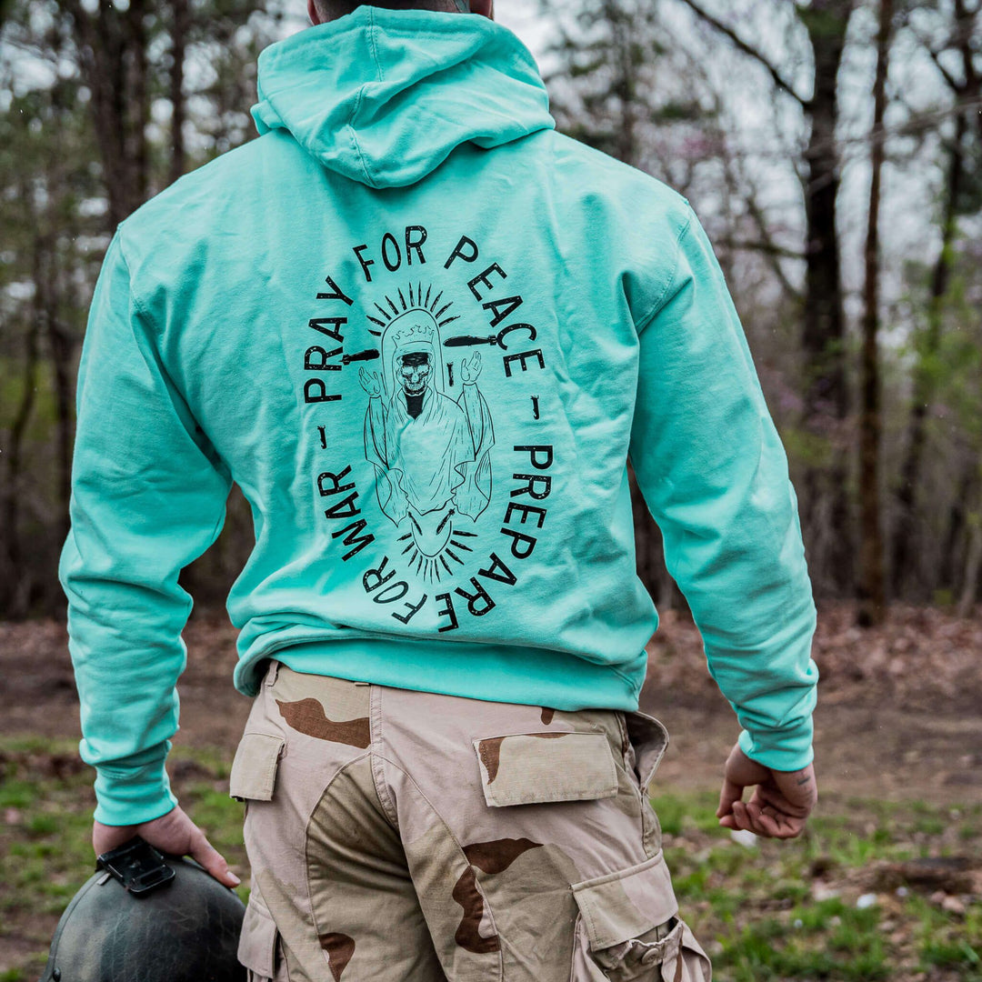 Pray for peace. Prepare for war. Midweight hoodie for men in camo with orange details#color_mint