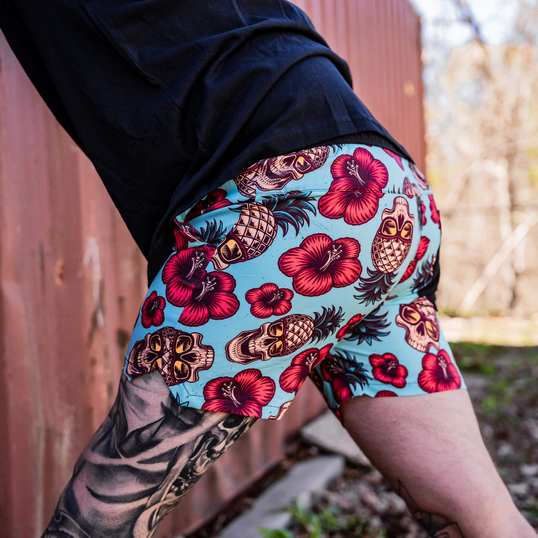 Men’s hybrid training and swim shorts with skulls, pineapples, and flowers #color_teal-pineapple-express