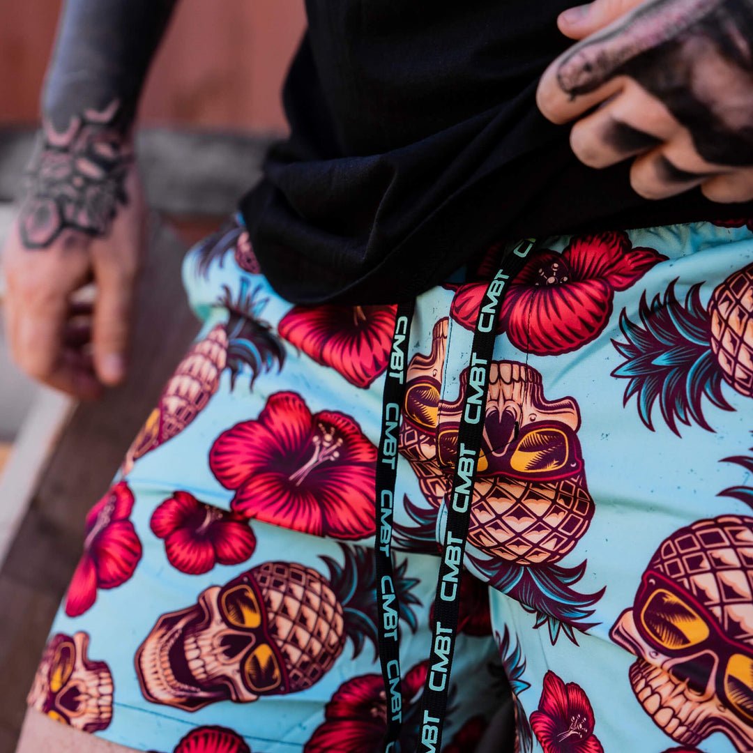 Men’s hybrid training and swim shorts with skulls, pineapples, and flowers #color_teal-pineapple-express