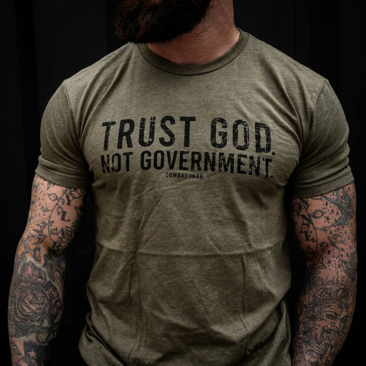 Men’s black t-shirt with the message “Trust God. Not government.” with letters and a American flag on the sleeve #color_military-green