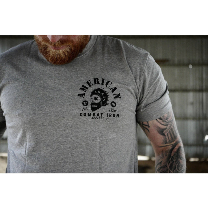 A men’s t-shirt with the words “American chaos” with a bearded skull in the front and the words “Combat Iron” below the skull #color_gray