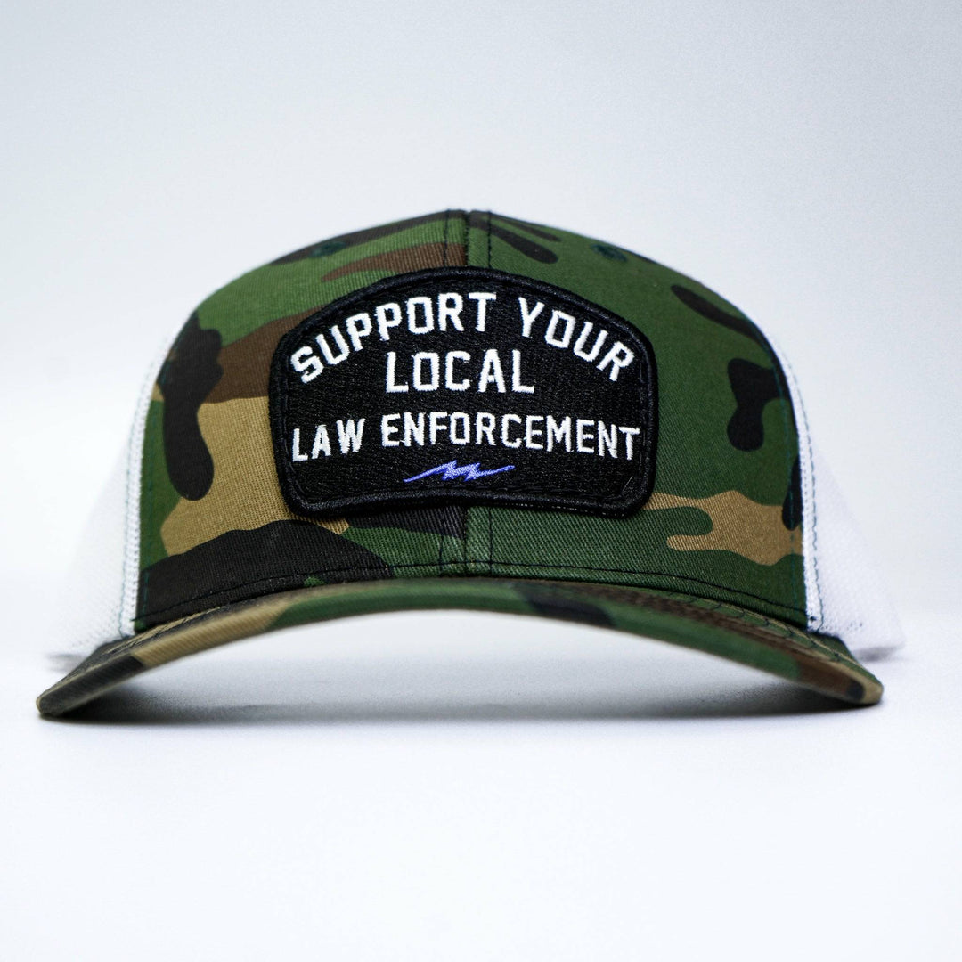 A mid-profile snapback hat with a patch on the front that says “Support your local law enforcement” #color_bdu-camo-white