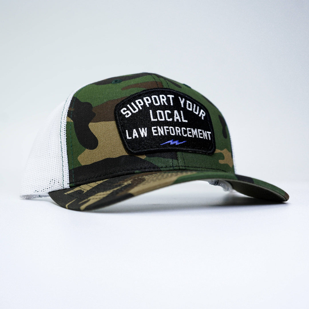 A mid-profile snapback hat with a patch on the front that says “Support your local law enforcement” #color_bdu-camo-white