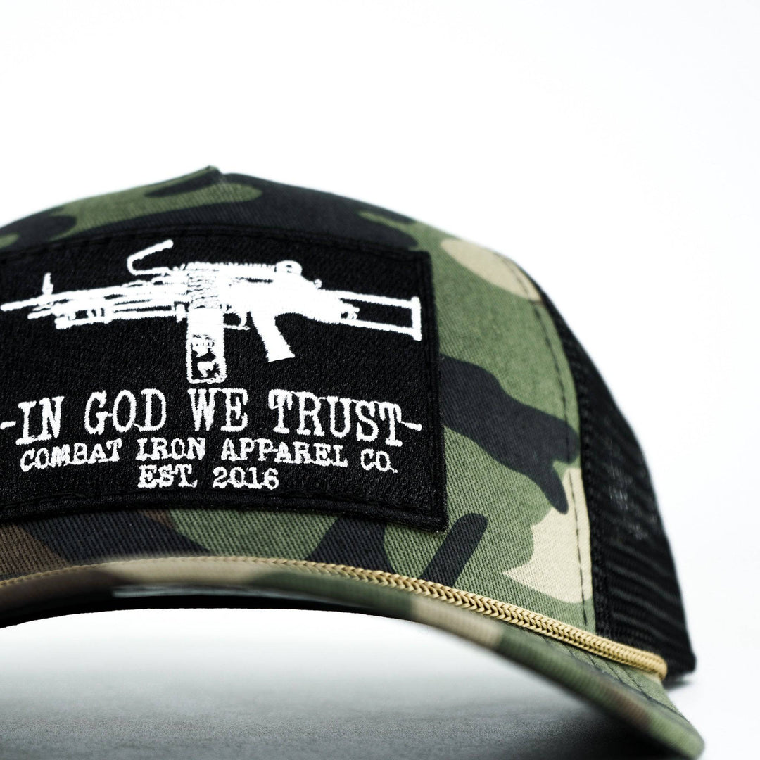 A camo retro rope snapback with a black patch saying “In God we trust” in white letters and an LMG on it #color_bdu-camo-black