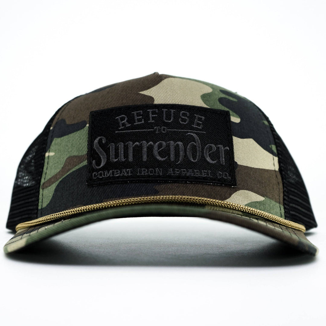 A camo retro rope snapback with a black patch that says “Refuse to surrender” #color_bdu-camo-black