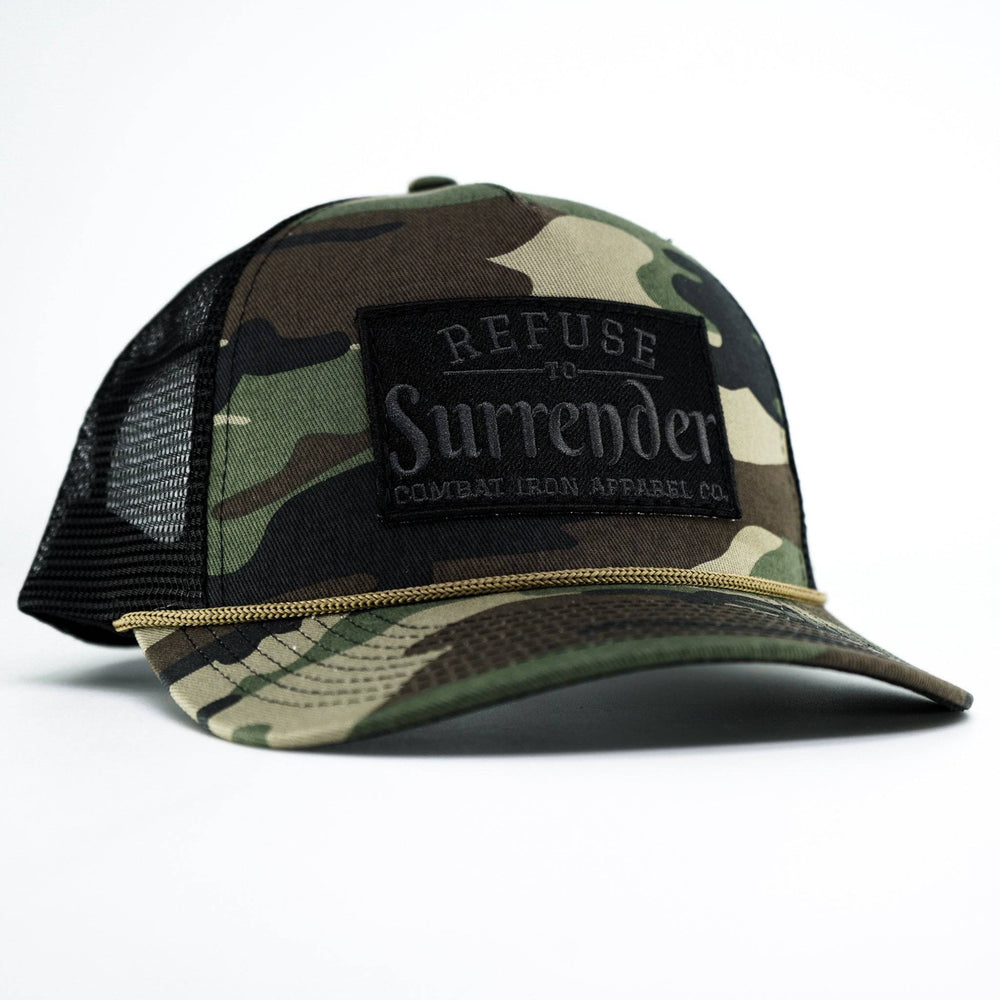 A camo retro rope snapback with a black patch that says “Refuse to surrender” #color_bdu-camo-black