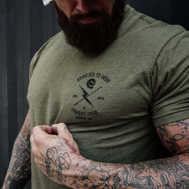 Men’s t-shirt with the print that says “Addicted to iron, combat iron” and a bolt, a barbell, and a skull in the front  #color_military-green