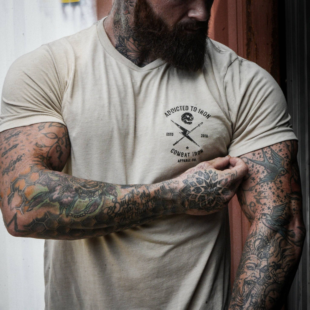 Men’s t-shirt with the print that says “Addicted to iron, combat iron” and a bolt, a barbell, and a skull in the front  #color_tan