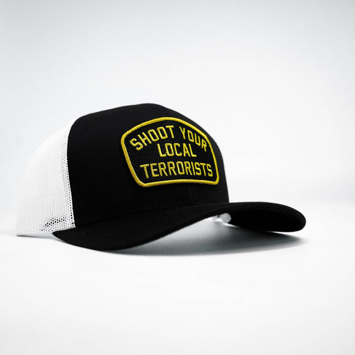 Mid-profile mesh snapback hat in black with a patch that says “Shoot your local terrorists” in yellow #color_black-white